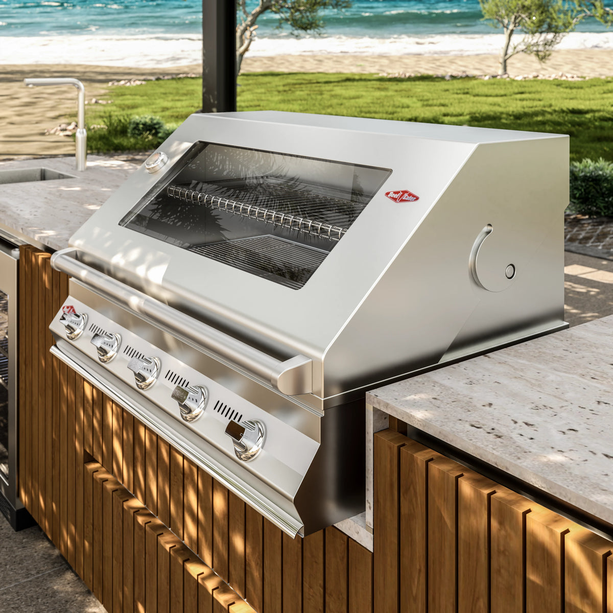Close view of the Al Fresco Kitchenette’s stainless steel grill, set into a travertine countertop above solid teak cabinetry.