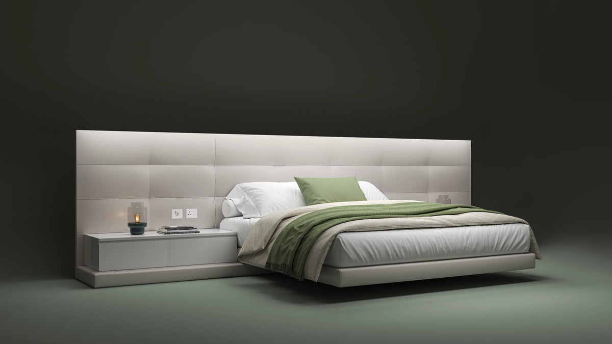 Angled view of the beige Sublime bed with rectangular tufted cladding, an elevated platform, and integrated nightstands.