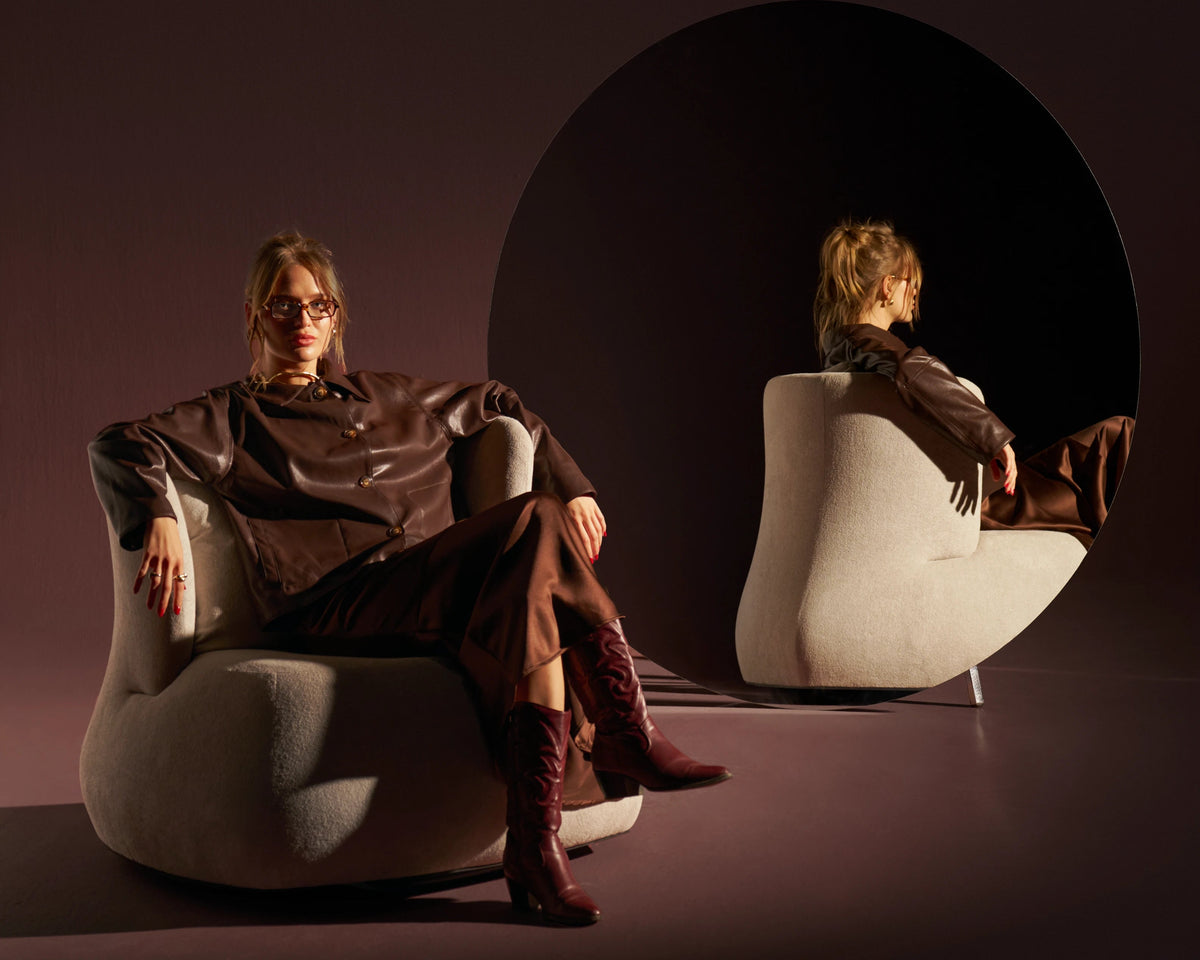 Front and rear views of the cream Belly armchair, showing its generous seat and wraparound U-shaped backrest.