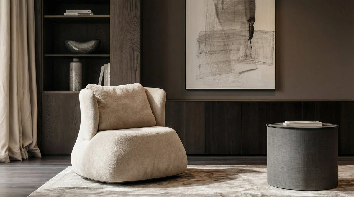 Cream Belly armchair with a feather-filled back cushion and wraparound backrest, styled in a contemporary living room.