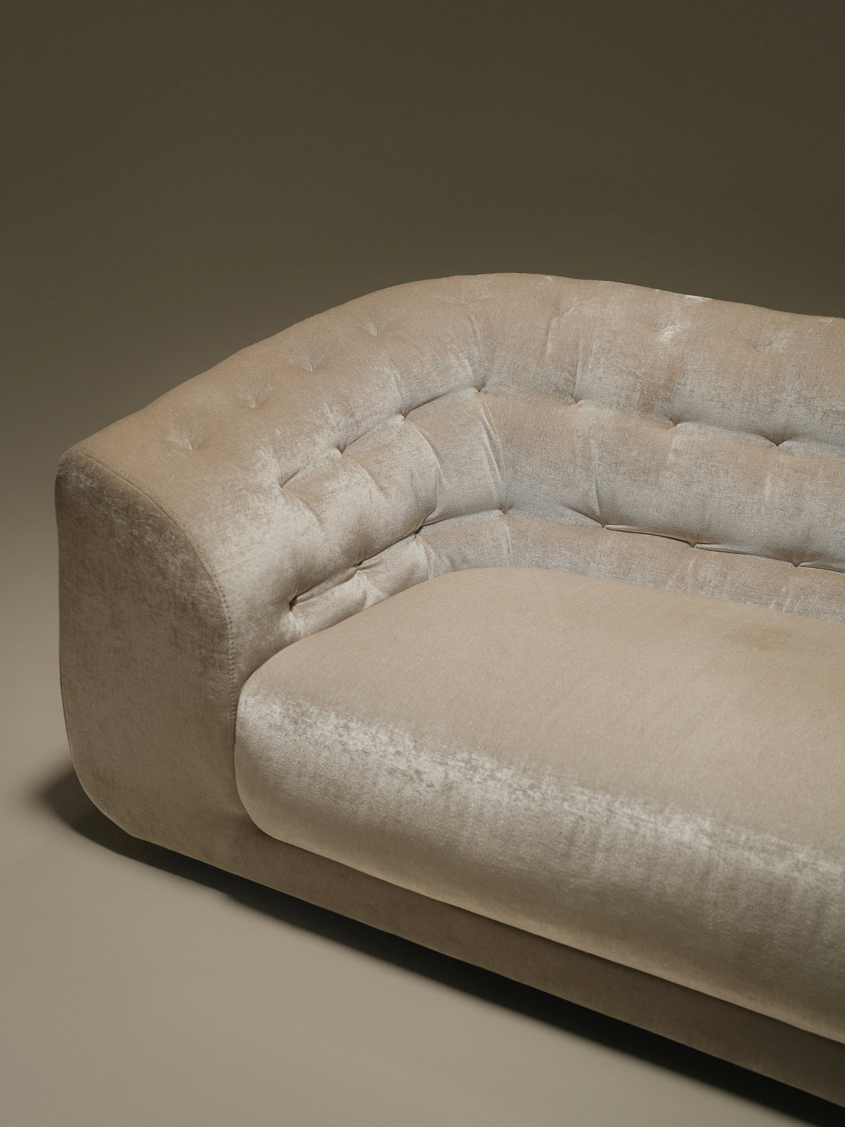 Close-up of the beige Cloud sofa, highlighting its handmade capitonné tufting, curved armrest, and soft upholstered finish.