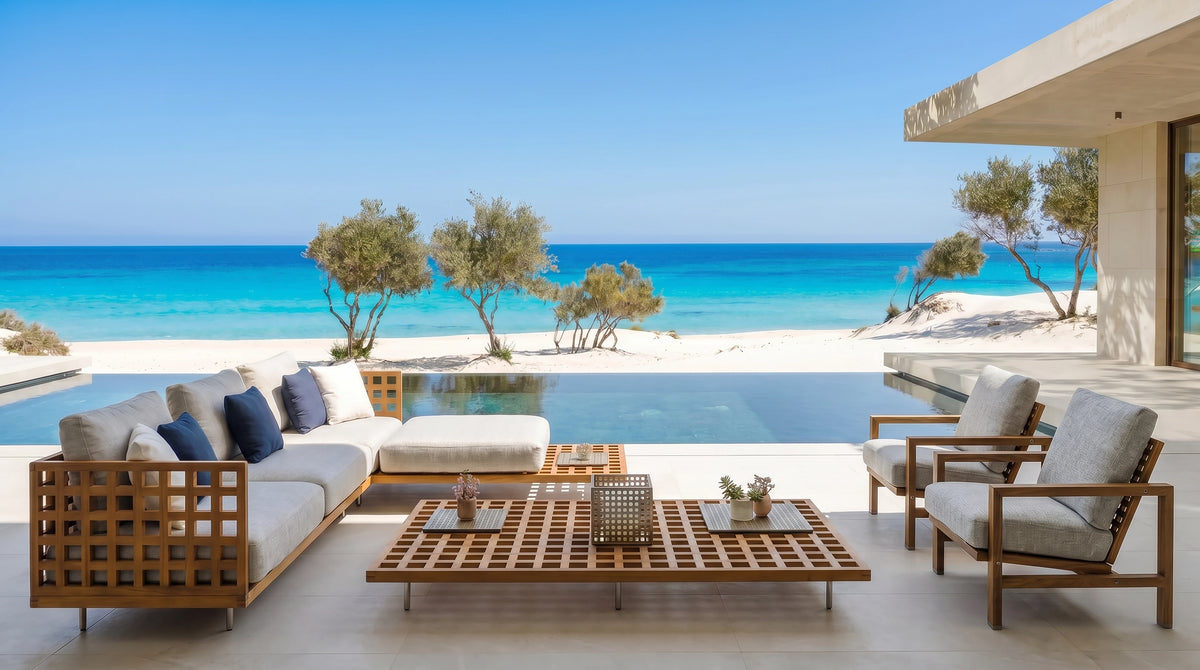 Cocoon modular outdoor sofa with lattice teak frames, matching armchairs and a grid coffee table on a seaside terrace.