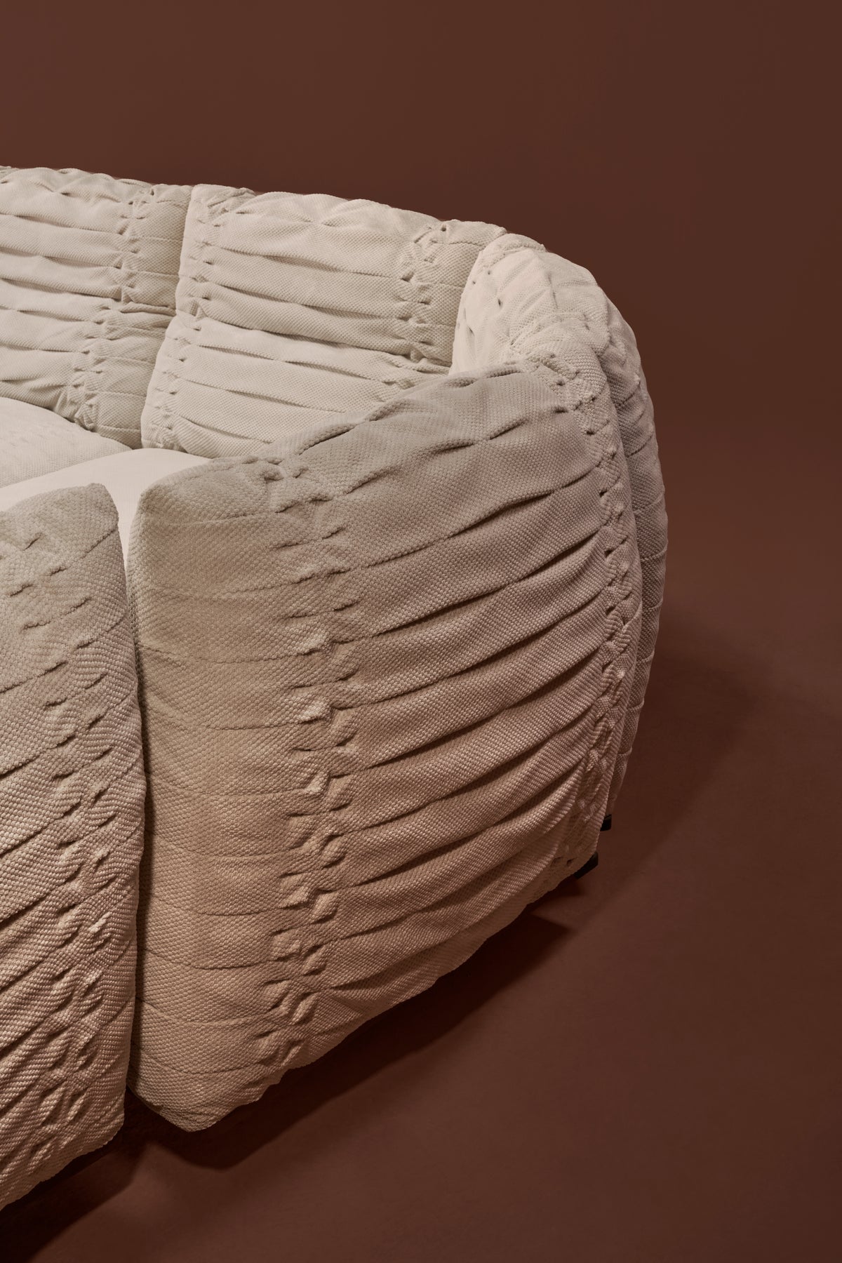 Close-up of Crusty sofa back in textured fabric, showing bold pleated hand stitching and adjustable backrest detail.