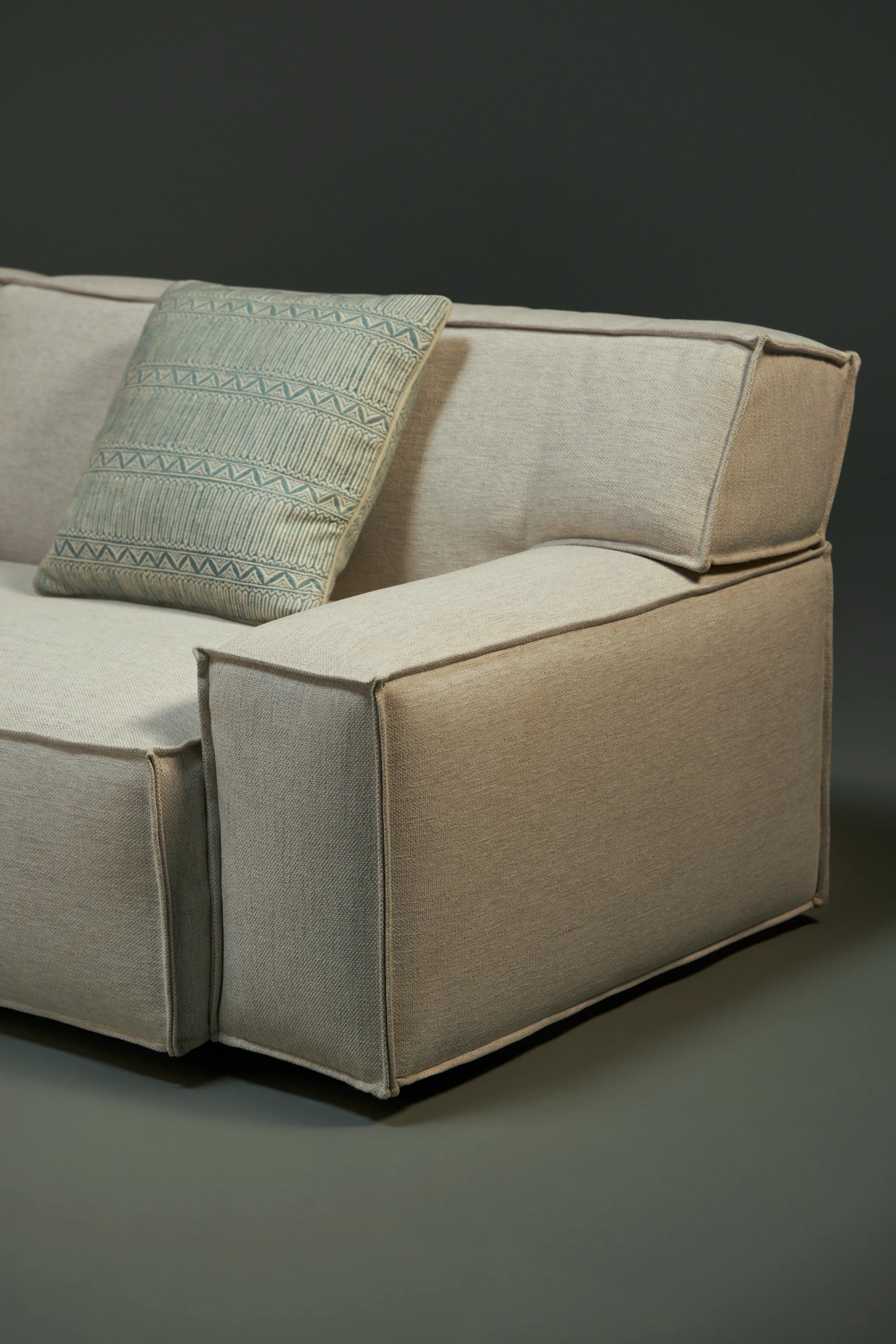 Close-up of the Da-Fluff Alto sofa, highlighting its wide upholstered arm, supportive slanted backrest, and French seams along the edges.

