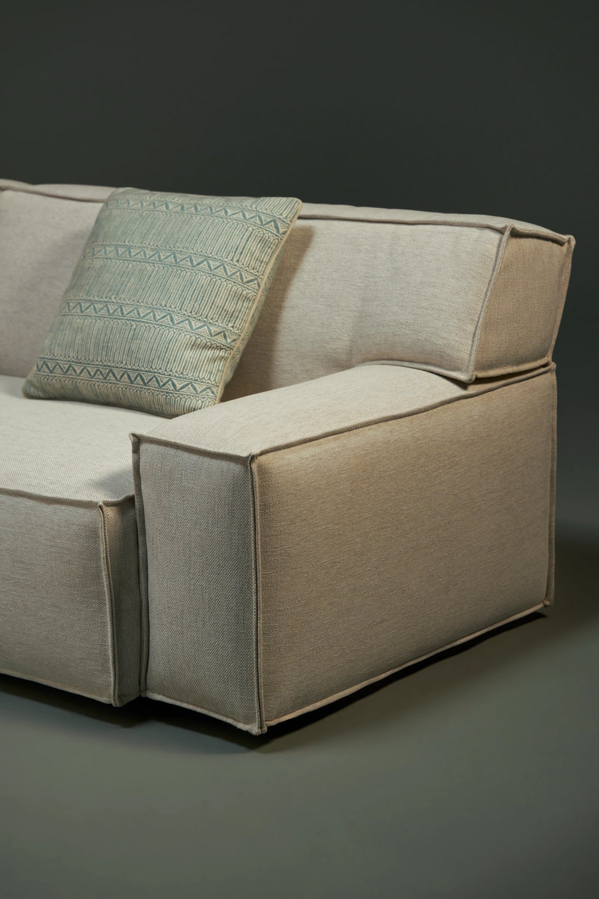 Close-up of the Da-Fluff Alto sofa, highlighting its wide upholstered arm, supportive slanted backrest, and French seams along the edges.
