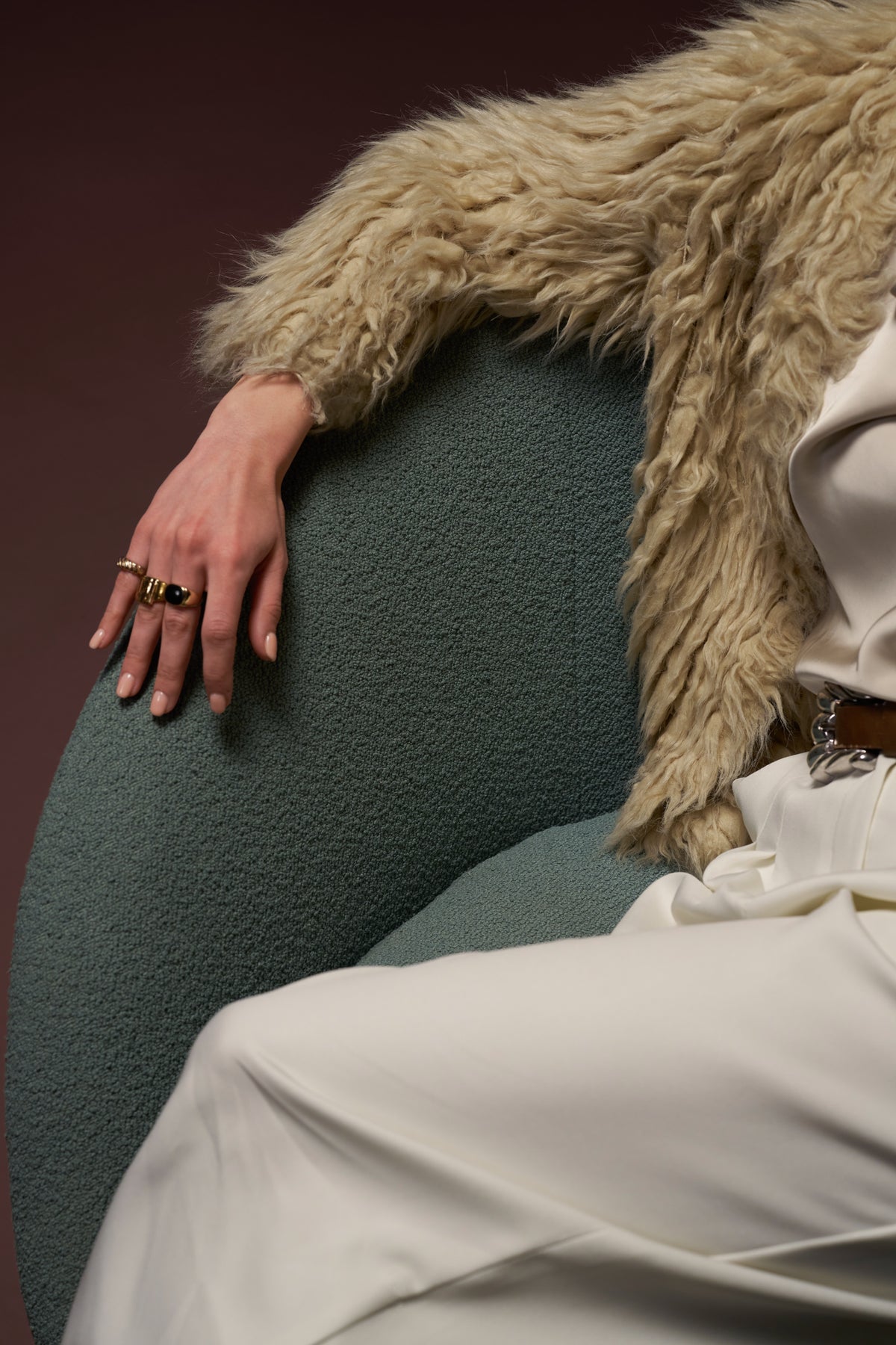 Close-up of Darby armchair in textured green fabric, highlighting soft rounded upholstery and stitching detail.