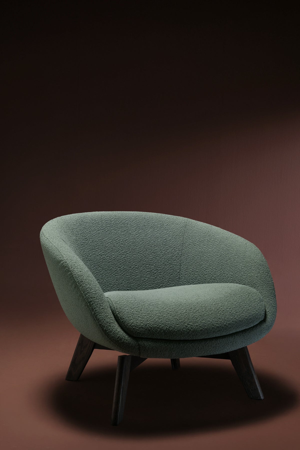 Front view of the teal Darby armchair with a curved backrest, upholstered seat cushion, and dark solid wood legs.