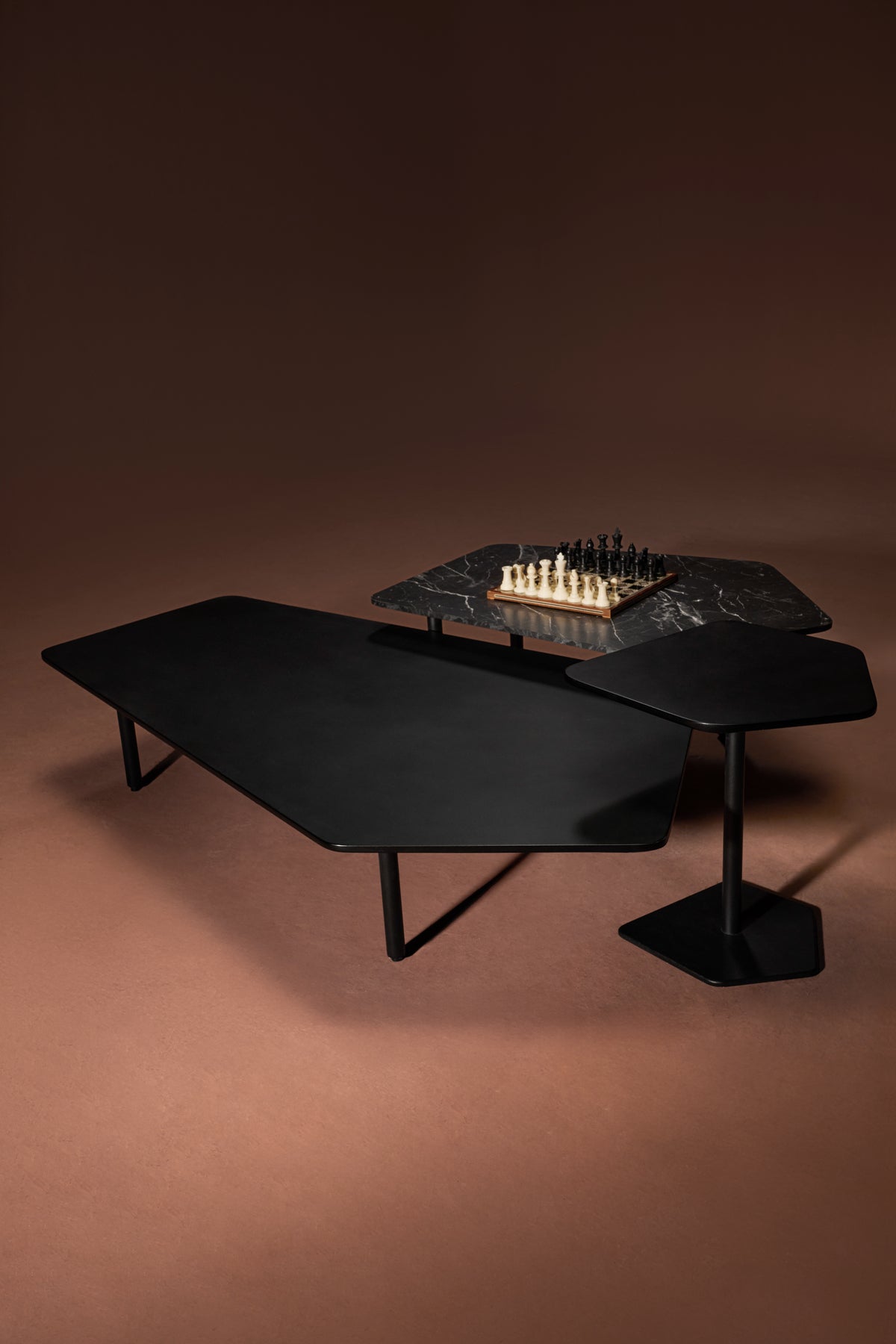 Echo tables in black marble laminate with freeform geometric tops and slim metal legs.