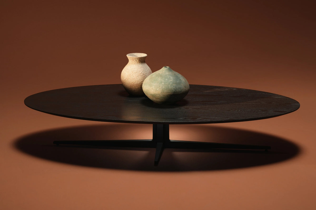 Front view of the low-profile Ellipse coffee table, featuring an elongated oval solid oak top and black cross-base support.
