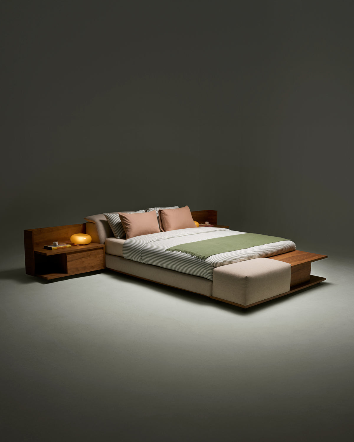 Angled view of Estrella Bed highlighting platform mattress, wooden veneer banquette with cushioned seat, and slim profile headrest.