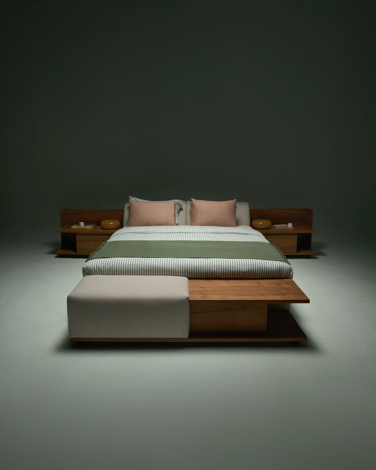 Estrella Bed with slim adjustable headrest and integrated wooden banquette at the foot, styled with striped bedding and accent pillows.