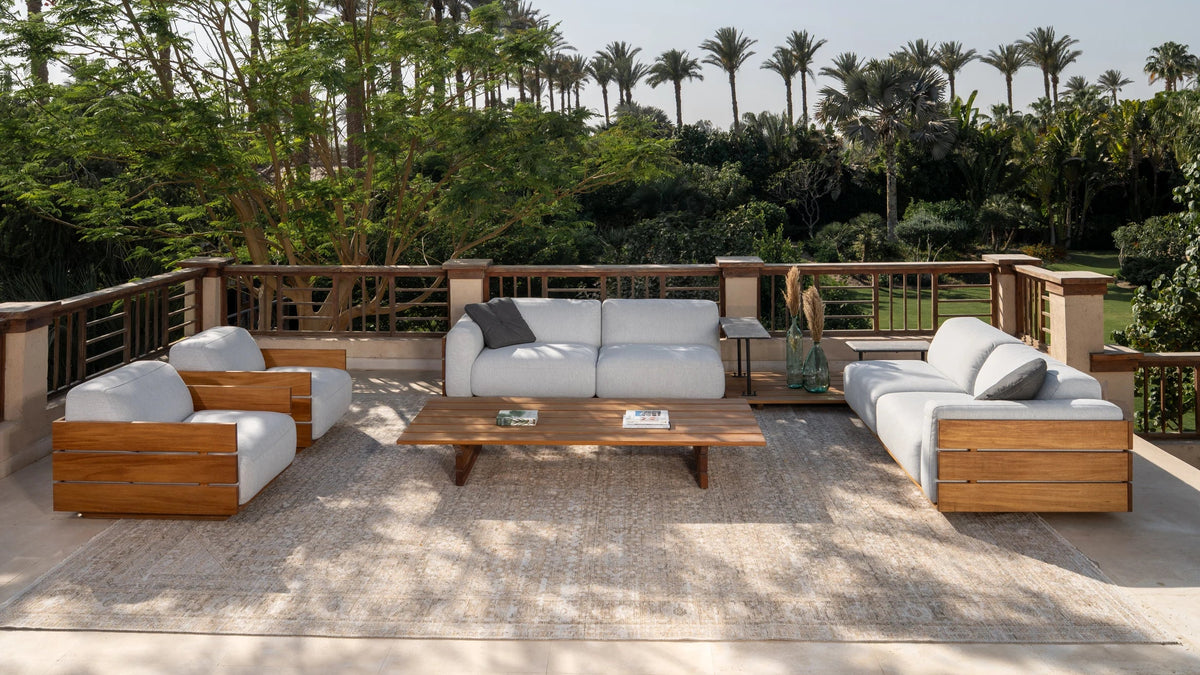 Wide view of Fatty sofa set arranged on a terrace, featuring teak wood slat panels, paired with optional marble accent tables matching Fatty coffee table for a complete outdoor lounge setup.