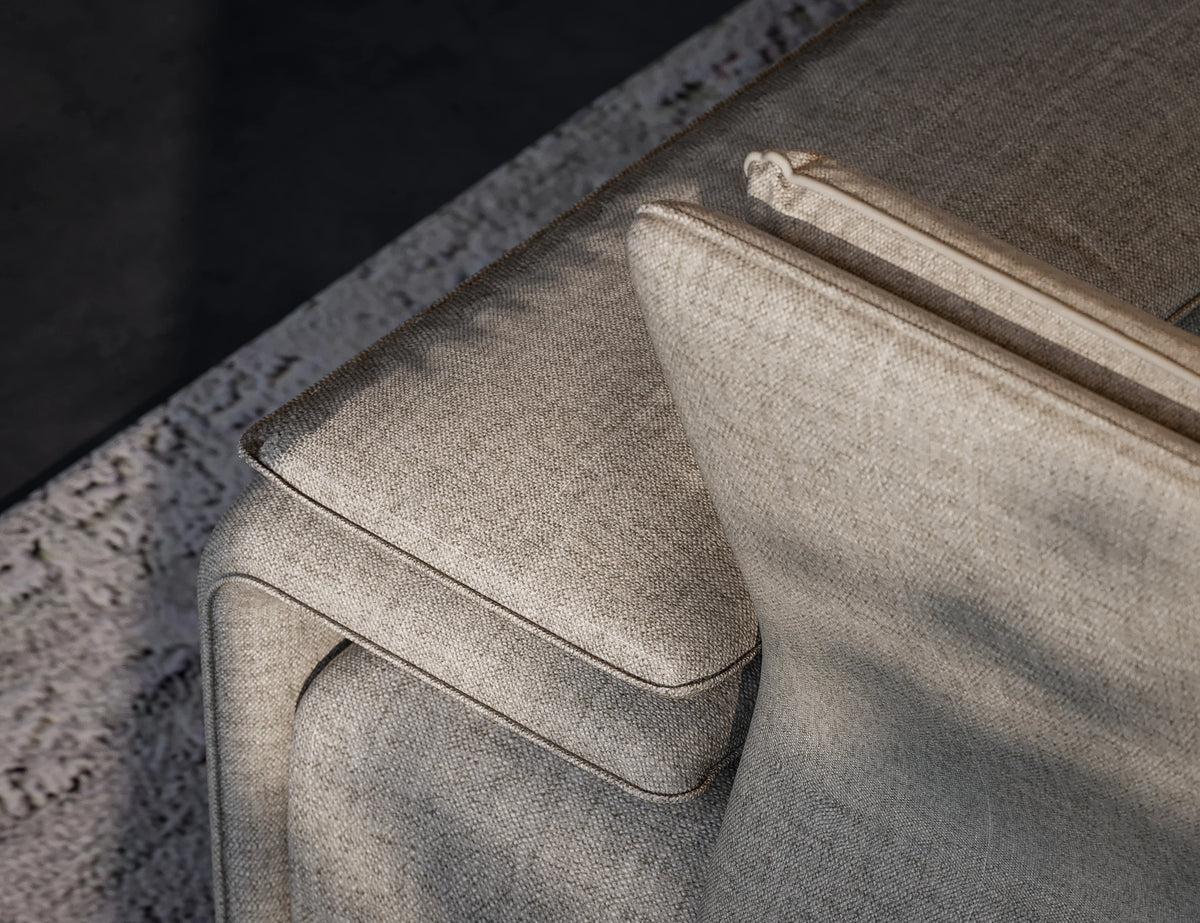 Close-up of the beige Flexor Sofa showing its upholstered armrest, adjustable headrest, and piped edges.