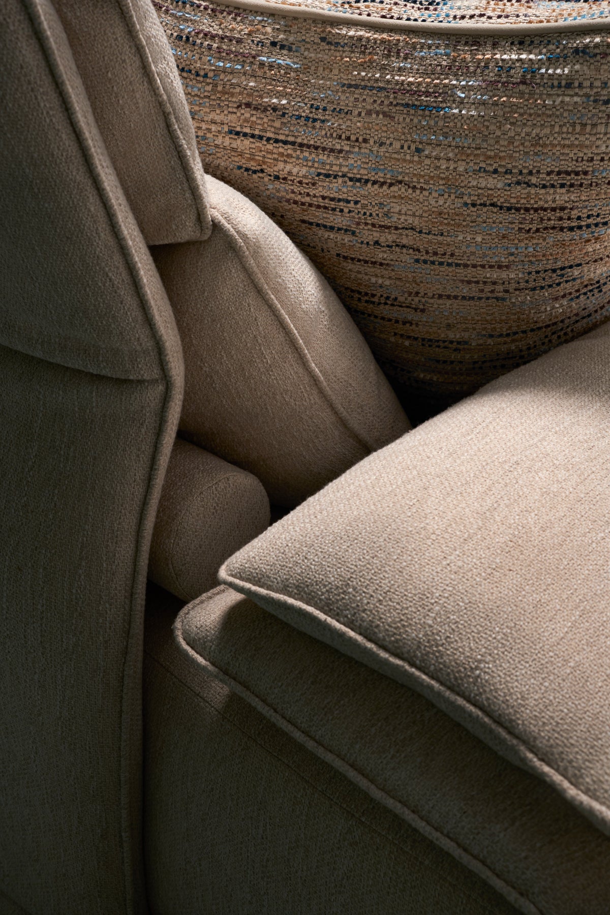 Close-up of Flexor Sofa backrest and cushions in beige upholstery with piping seams.