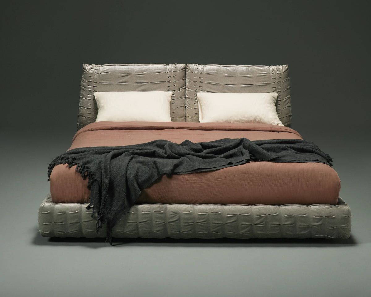 Front view of the Crusty bed with two adjustable upholstered backrests and hand-stitched pleating across the grey frame.