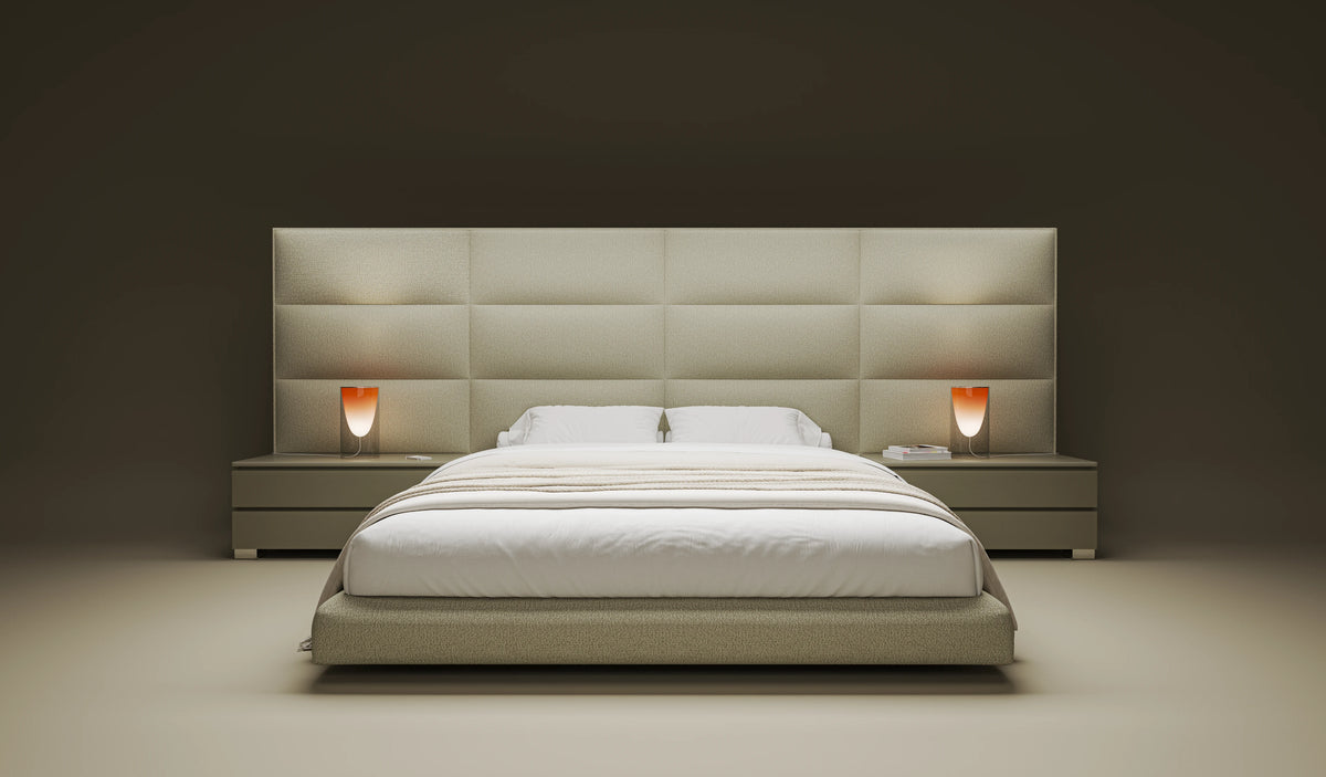 Front view of the beige Platinum bed with a curved padded platform, extended bombé cladding, and matching nightstands.