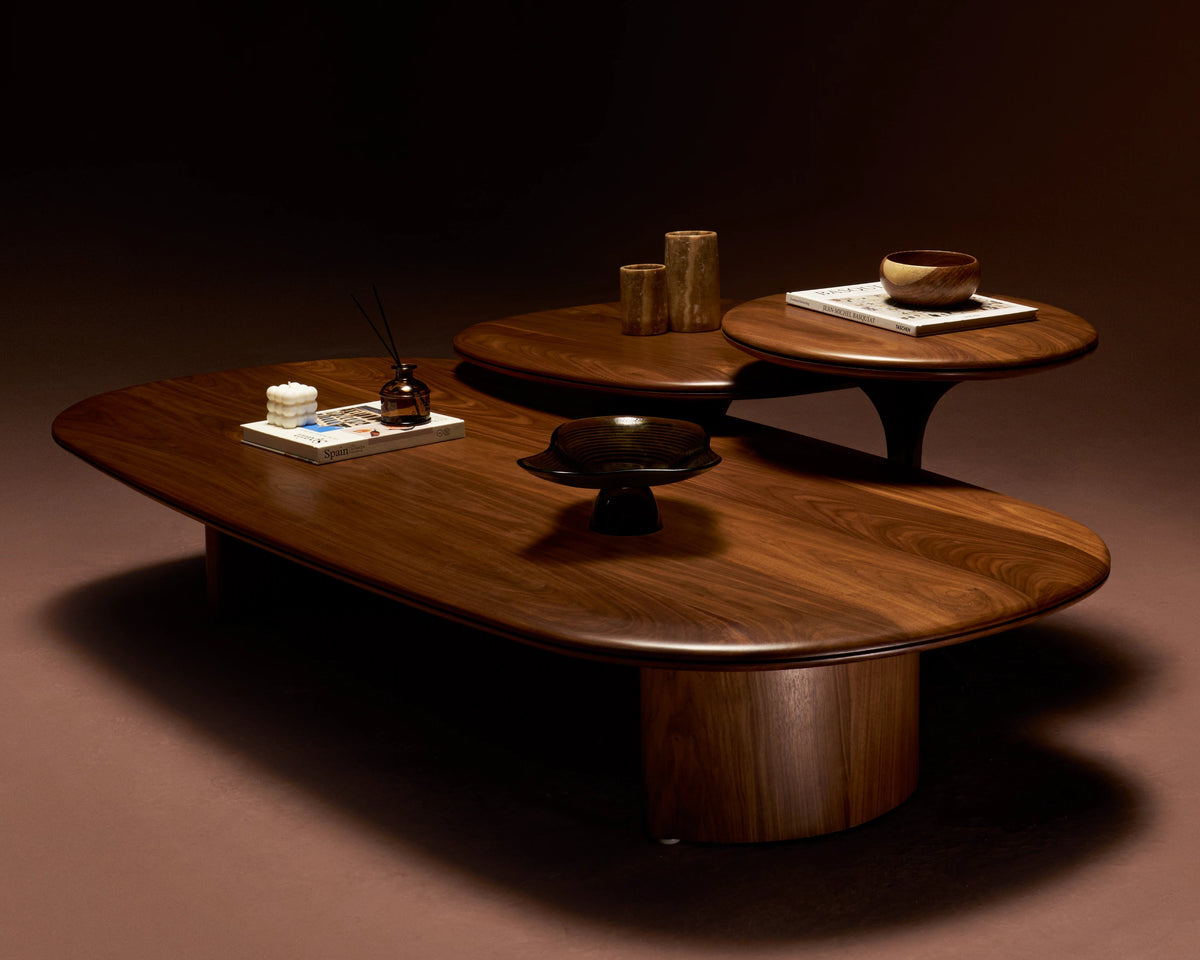 Glide coffee table with solid walnut top and matching wood veneer legs, rounded form with a central-split carved detail.
