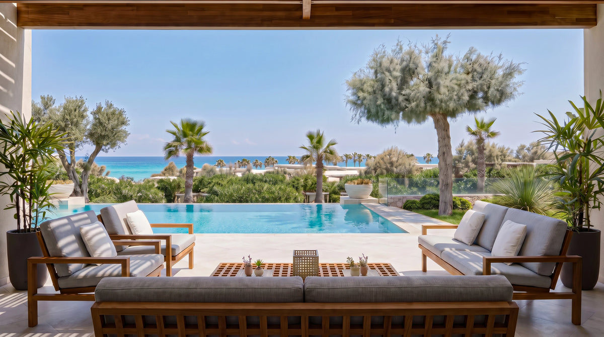 Three Hive outdoor sofas with open teak frames and light grey cushions arranged around a lattice coffee table beside a swimming pool.