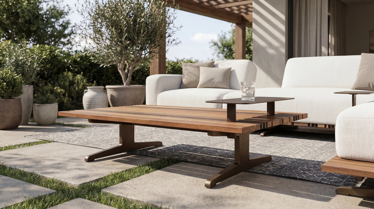 Lodge outdoor table with a slatted teak top and raised accent table, arranged with white Lodge sofas in a garden patio setting.