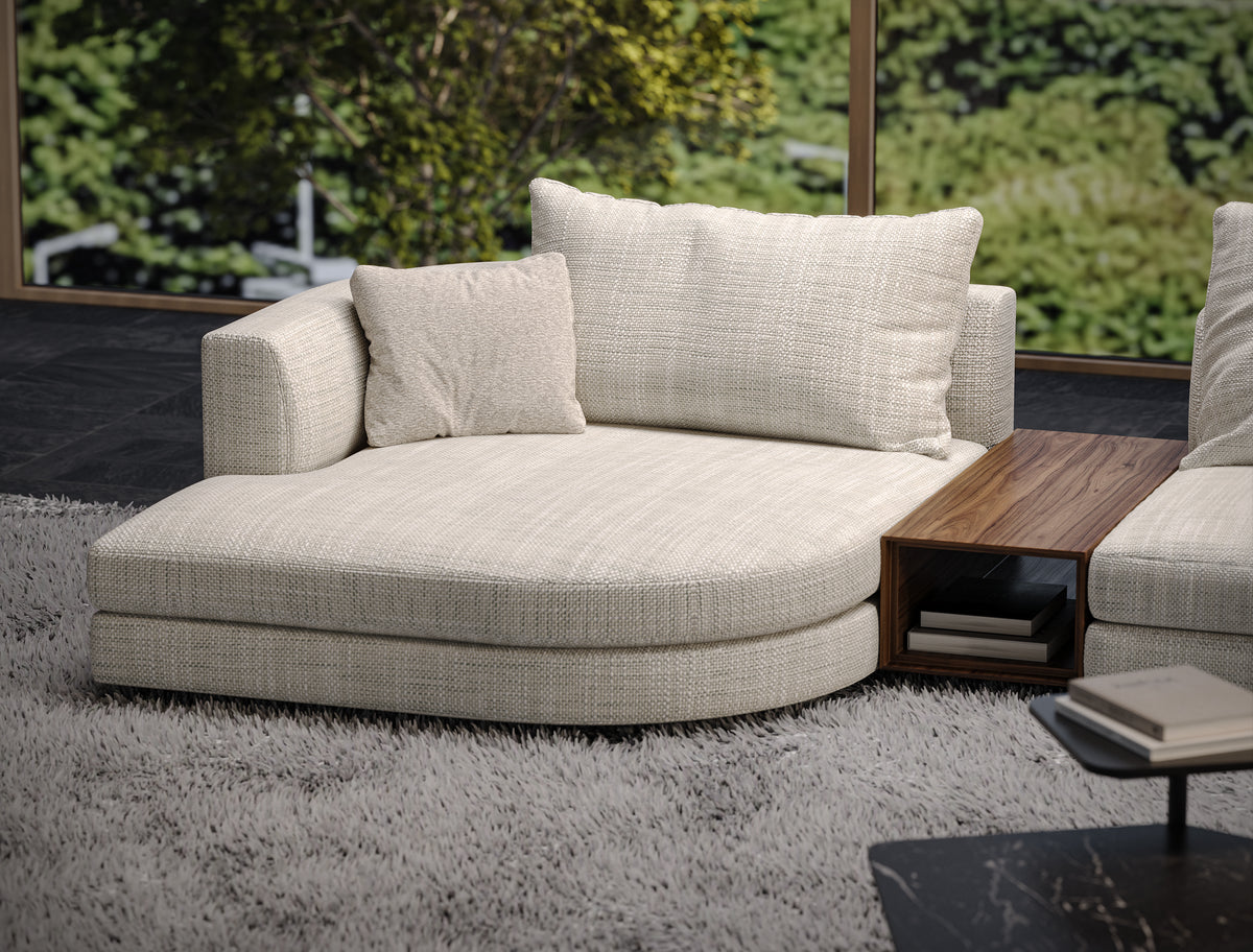 Monti curved chaise in textured beige upholstery with soft back cushions and an integrated wood table featuring open storage.