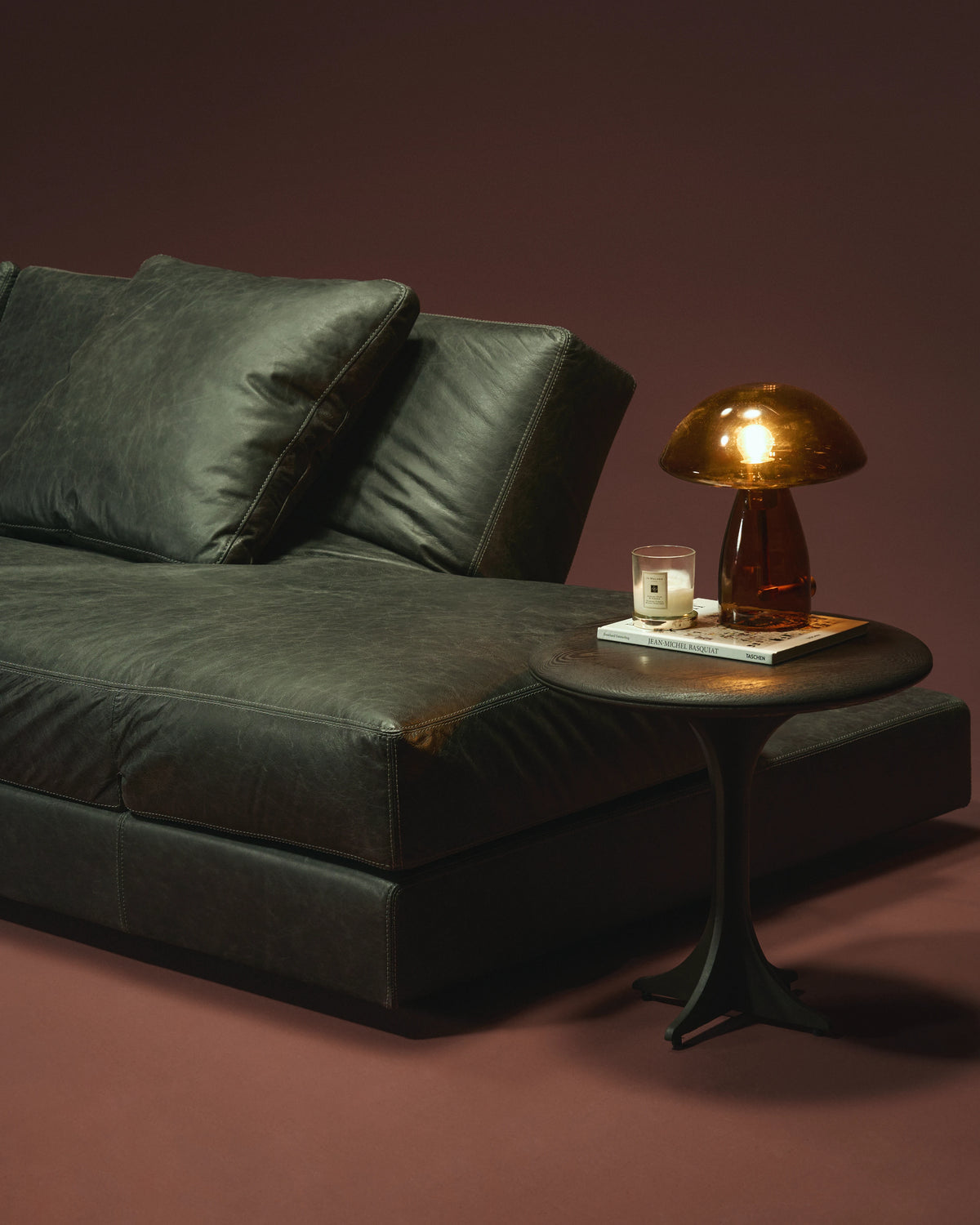Close-up of the black leather Panacea sofa with an adjustable backrest, deep seat, loose back cushion, and double topstitch seams.
