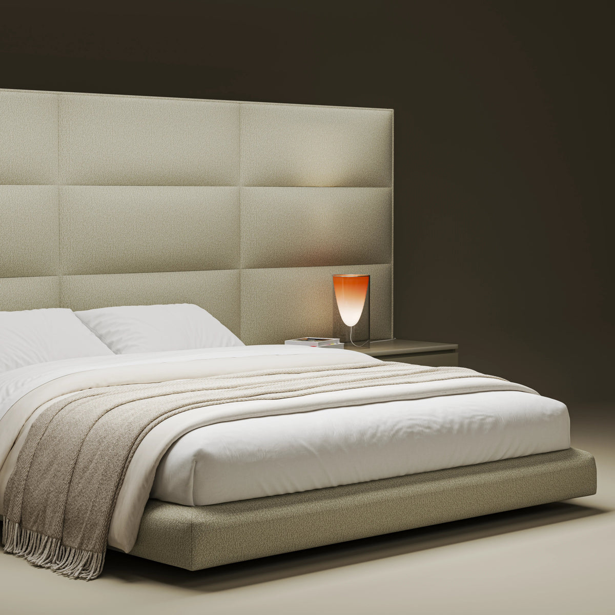 Close angled view of the beige Platinum bed highlighting its curved upholstered platform and padded bombé cladding.