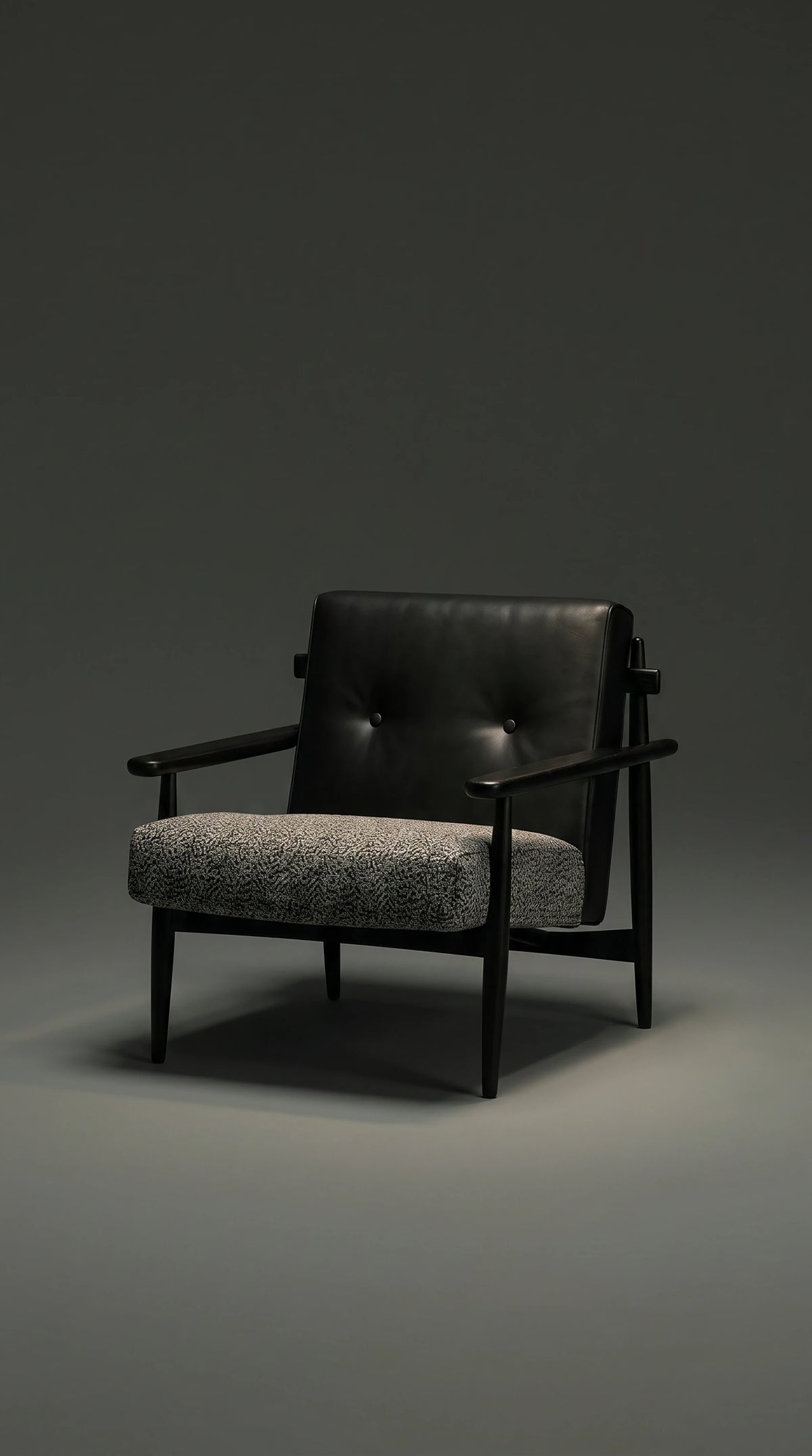 Front view of the Retro Lounge armchair with a black leather backrest, two-button capitonné detailing, textured grey seat, and dark solid wood frame.