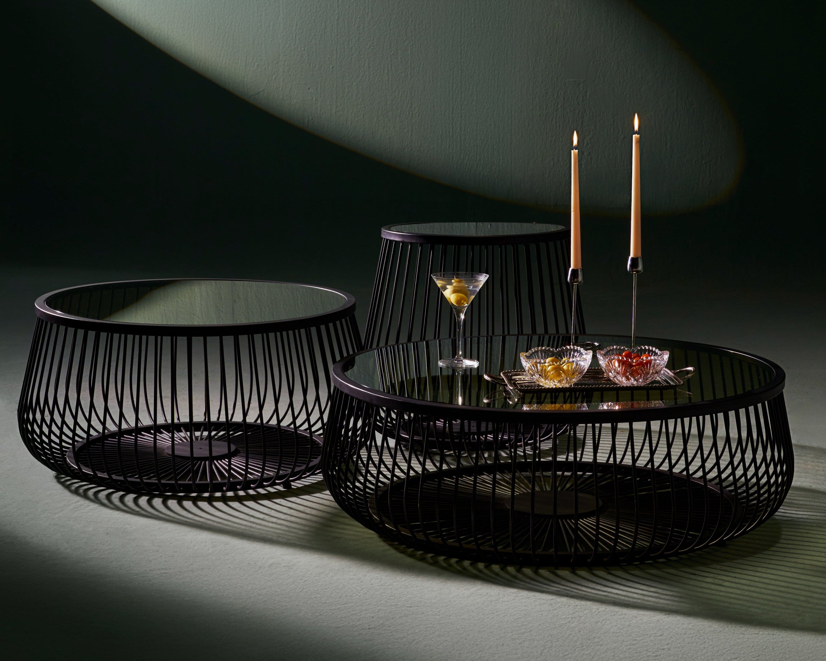 Set of three Ring tables with round black metal bases and glass tops, designed with an airy open-frame structure.