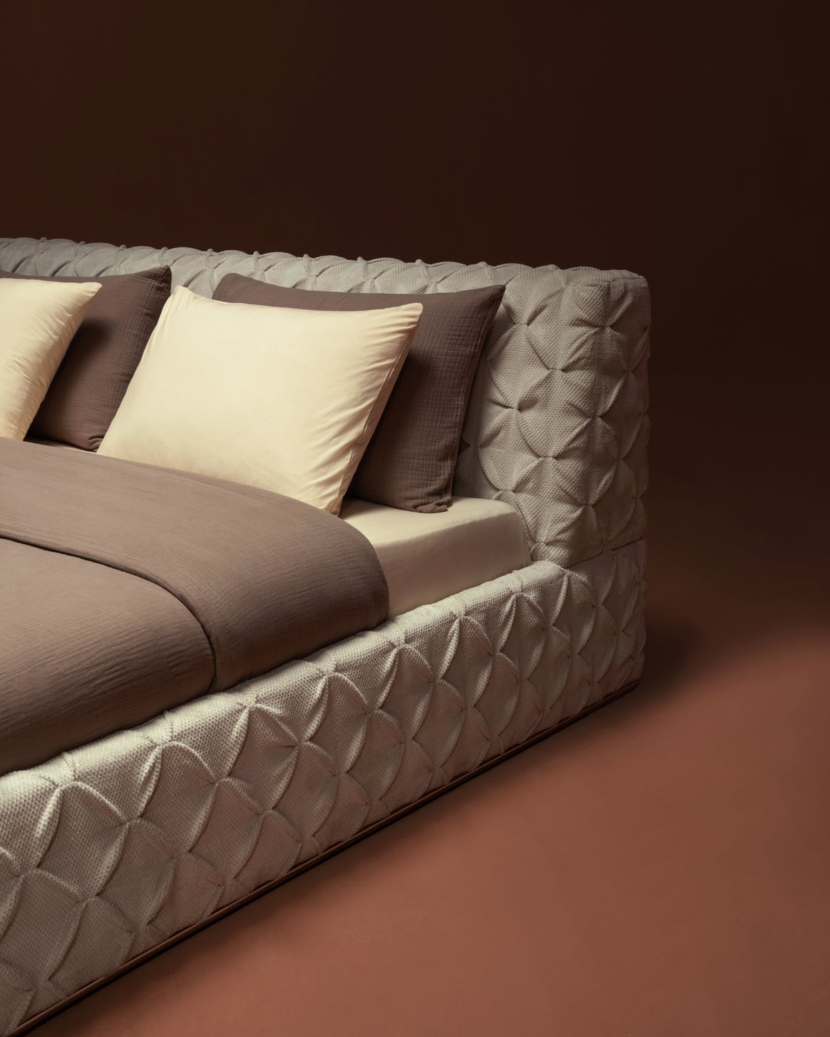 Side view of Ro-Blocks bed highlighting pinch pleated detailing on the headboard and frame, upholstered in cream fabric.