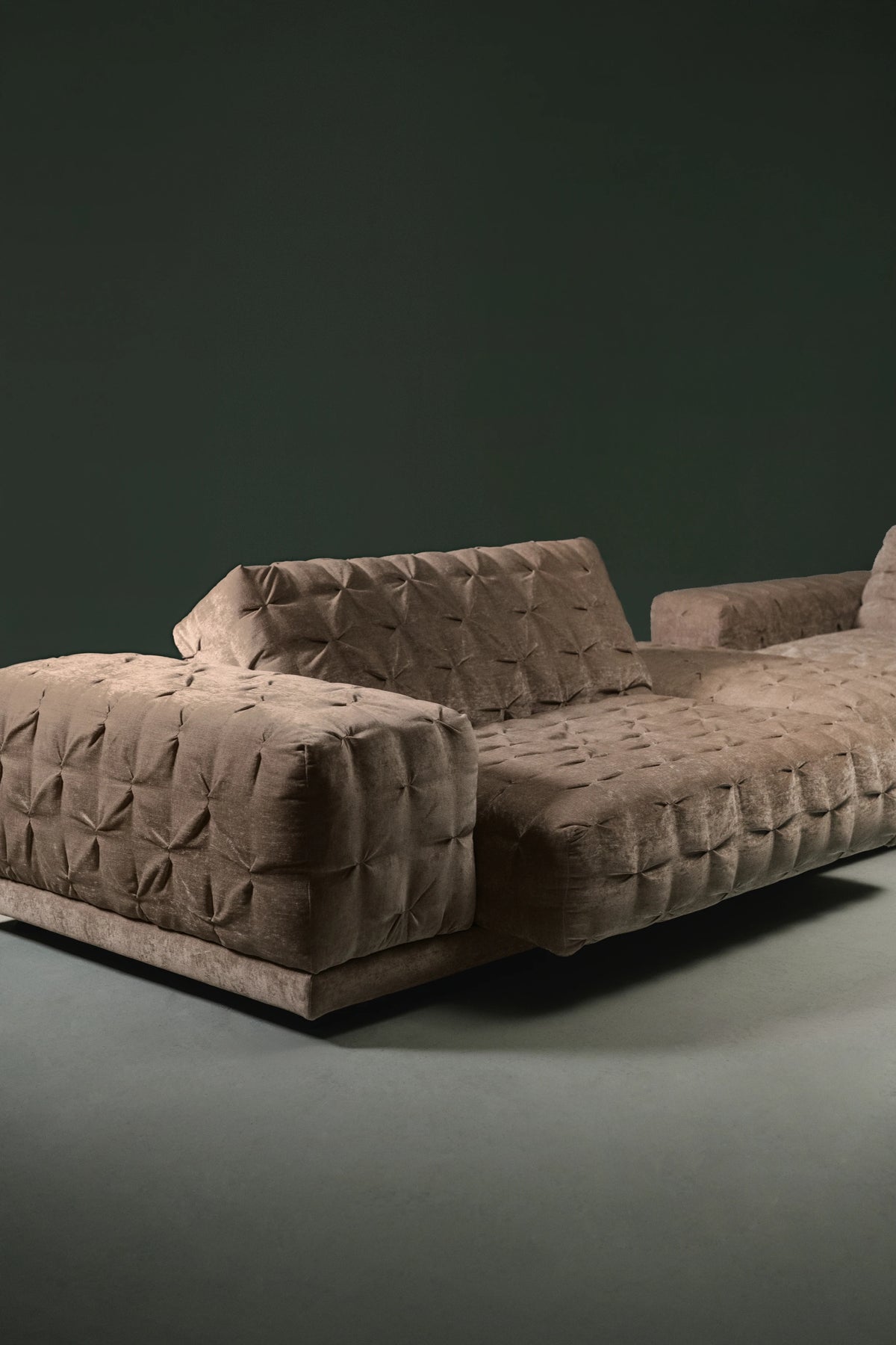 Angled view of Ro-Blocks in taupe velvet, hand-pleated upholstery with adjustable backrest and low, grounded base.