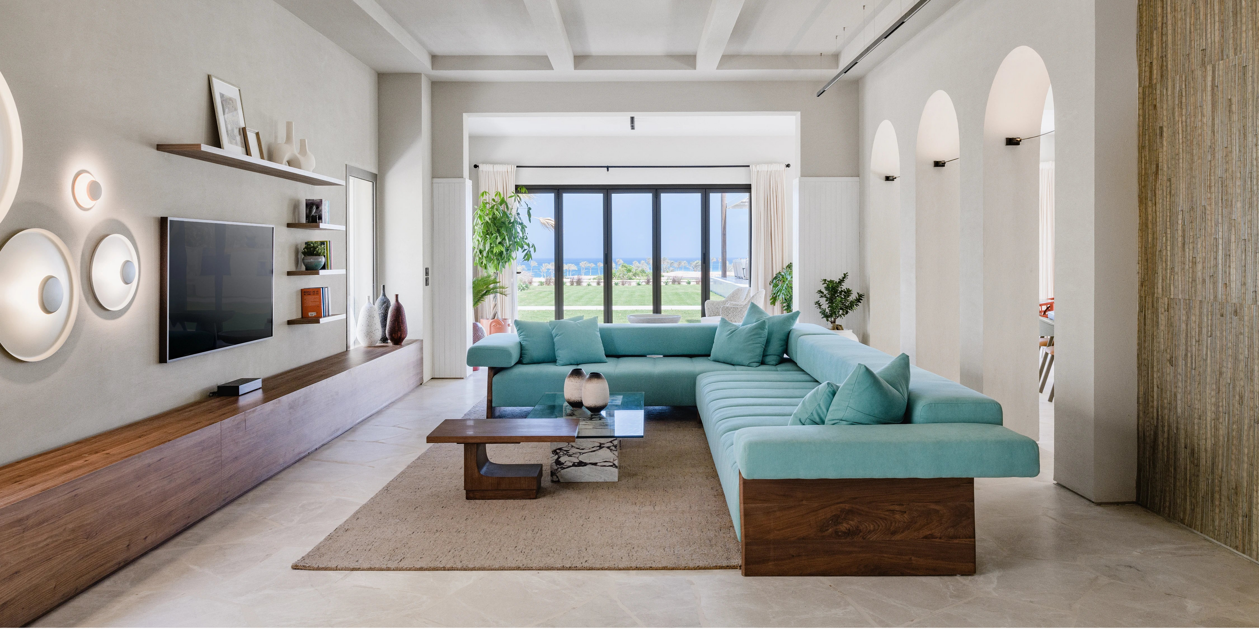 Blue Sol modular sofa in a bright contemporary villa, featuring generous seating, feather-filled cushions, and exposed solid wood panels.