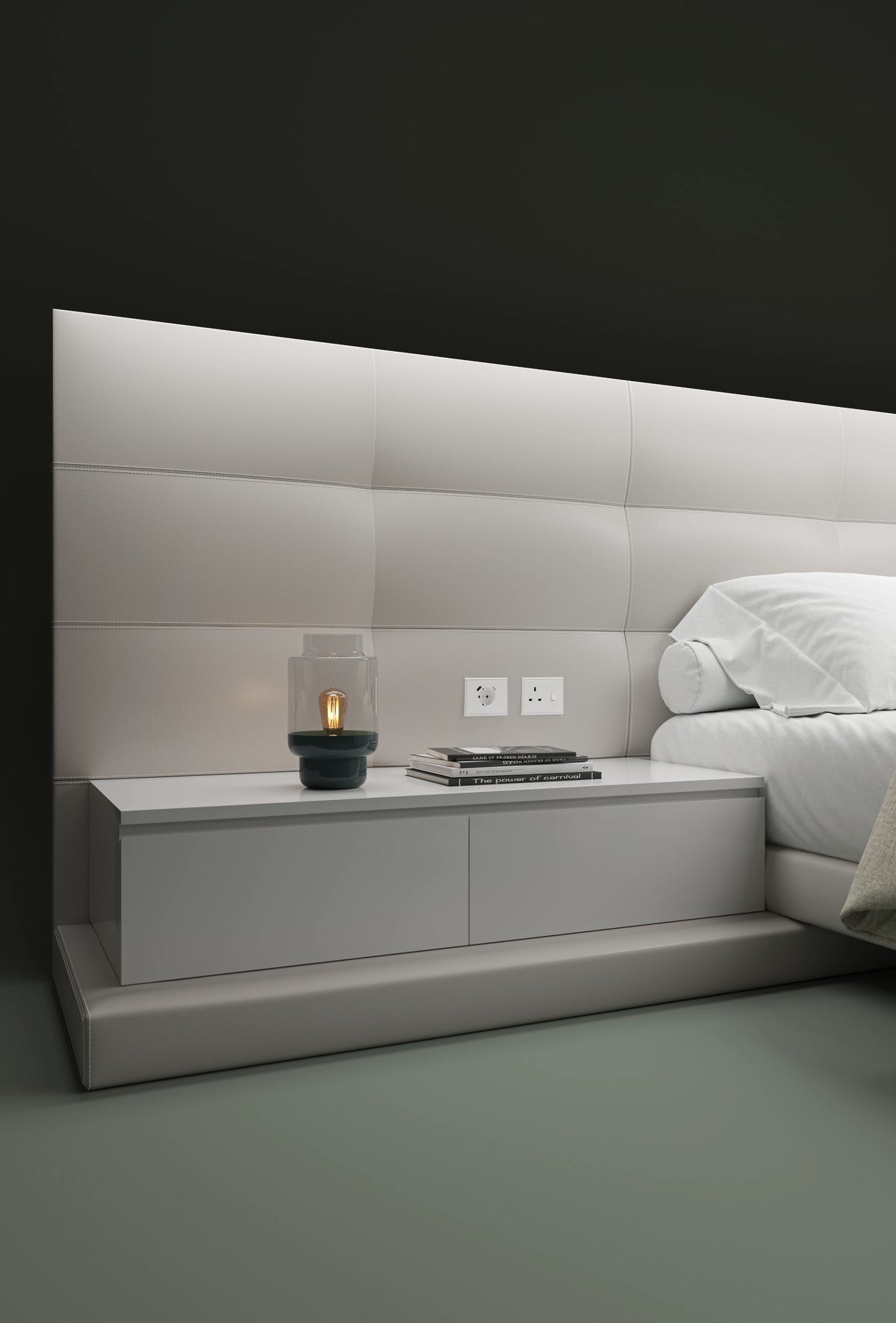 Close-up of the Sublime bed’s integrated nightstand, padded partition, built-in outlets, and rectangular upholstered cladding.
