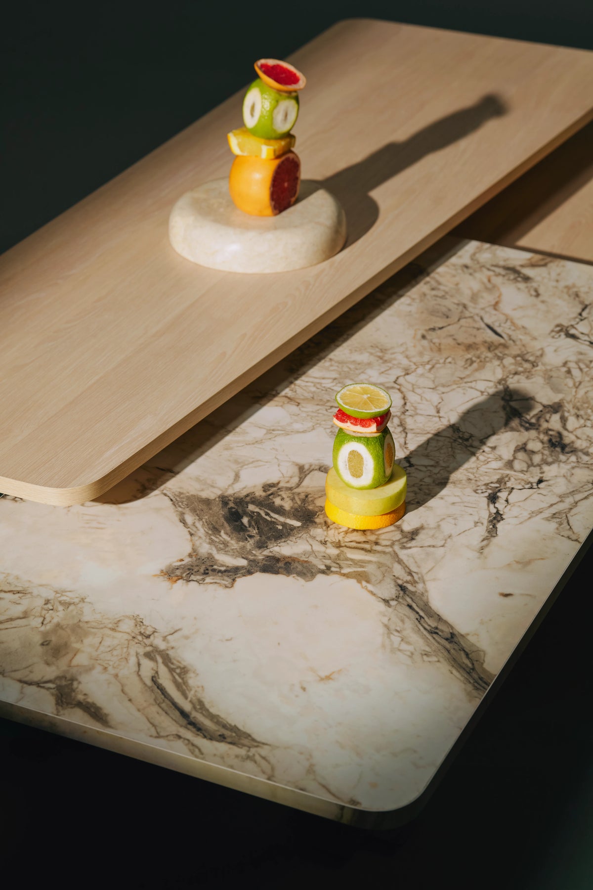 Detailed view of the Trio coffee table showing the marble laminate surface beneath a raised light wood veneer top.