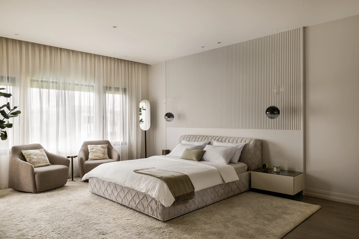 Two beige Windsor Low armchairs paired with the Ro-Blocks bed in a neutral bedroom.