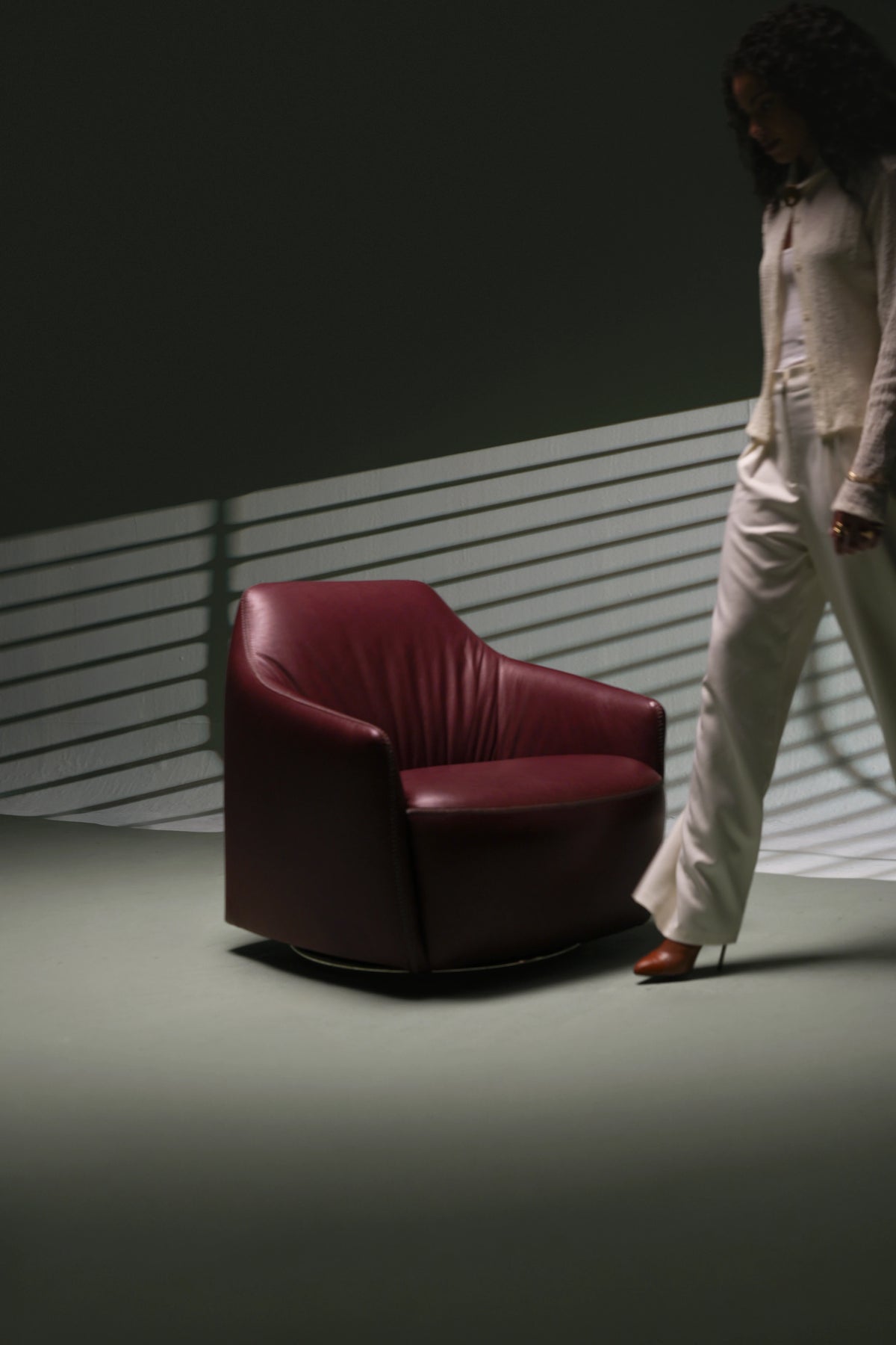 Burgundy leather Windsor Low armchair with a rounded profile, low backrest, overcast seam detailing, and swivel base.